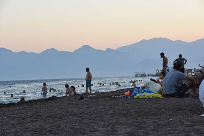 People on beach against clear sky