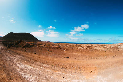 Scenic view of desert against blue sky