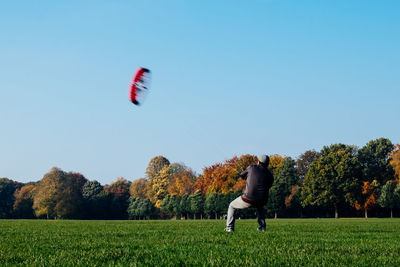 Man flying kite against clear sky