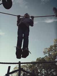 Low angle view of man jumping on swing