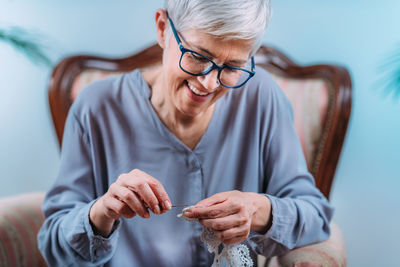 Crochet. senior woman doing crocheting at home. cognitive rehabilitation therapy.