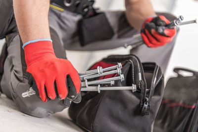 Midsection of worker holding work tools
