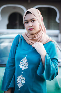 Portrait of young woman wearing hijab while standing outdoors