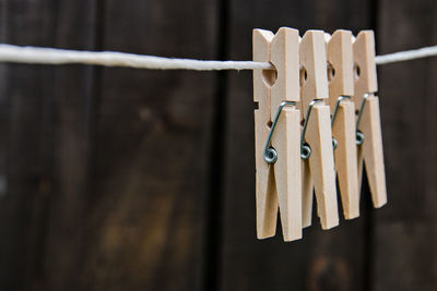 Clothespin hanging on line against wooden fence