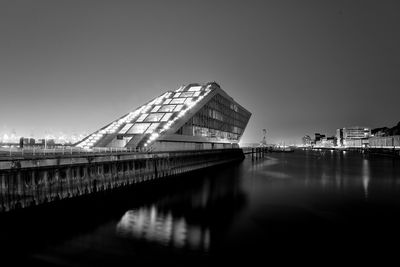 Reflection of building in water against clear sky