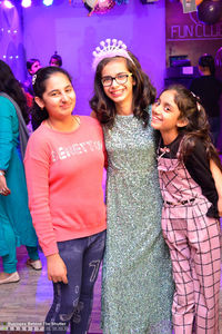 Portrait of smiling young women standing at night