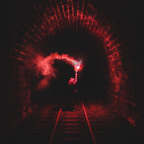 Woman with flaming torch in tunnel | ID: 88692069