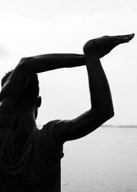 Rear view of man dancing against clear sky