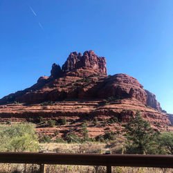 Low angle view of rock formations against clear blue sky