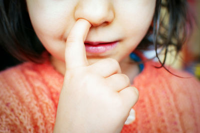 Close-up of girl picking nose