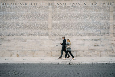 Man with umbrella walking on wall