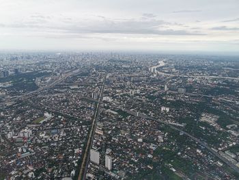 Aerial view of city against cloudy sky