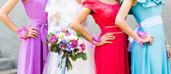 Midsection of bride holding bouquet