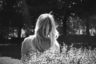 Woman wearing hat on field against trees