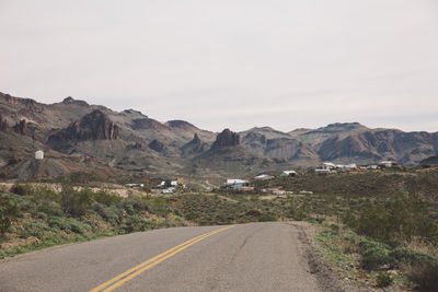 Road by mountains against sky