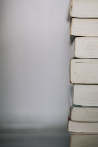 Close-up of books on table against wall