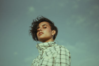Portrait of teenage girl looking away against sky