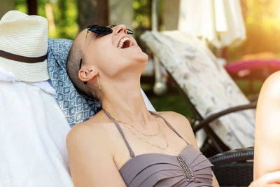 Cheerful woman relaxing at lounge chair