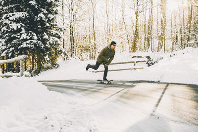 Full length of man skateboarding in snow