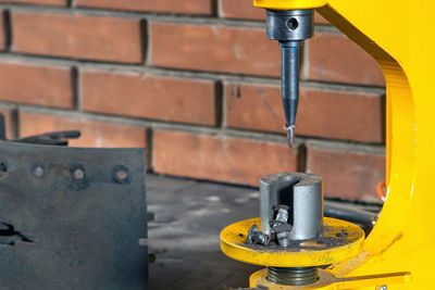 A close-up of yellow riveter machine for riveting brake pads in the workshop 