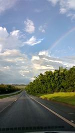 Road amidst trees against sky