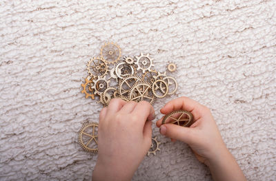 Cropped hands of child holding equipment on table