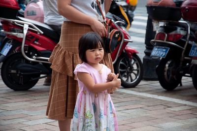 Full length of women standing on motorcycle