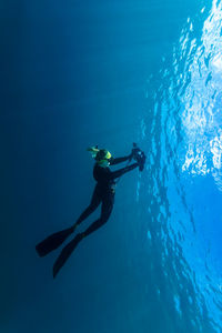 Woman swimming and taking photos in sea