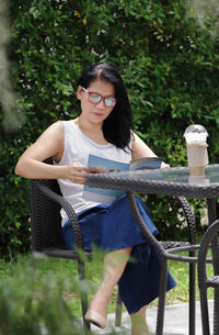 Woman reading book while sitting at cafe