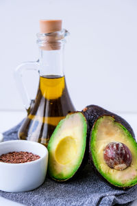 Olive oil in glass bottle with sesame and flax seeds. fresh ripe hass avocado. healthy eating. vegan