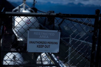 Close-up of text on chainlink fence