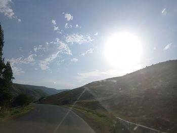 Road by mountains against sky