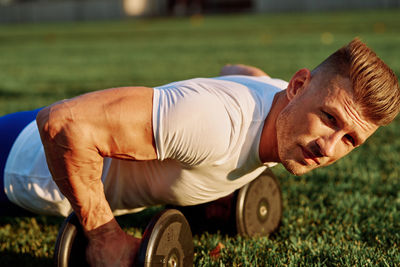 Low section of man exercising on field
