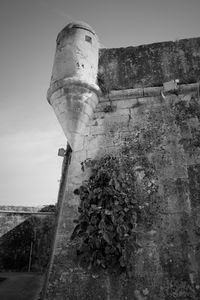 Low angle view of old water tower against sky