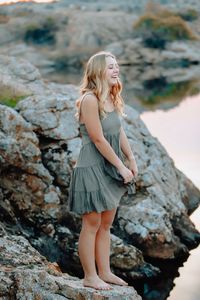 Full length of young woman standing on rock