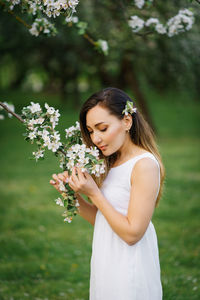 Portrait of a beautiful young girl in a blooming apple orchard in spring