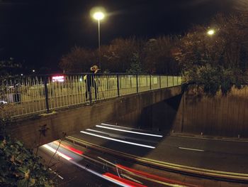 Illuminated road against sky at night