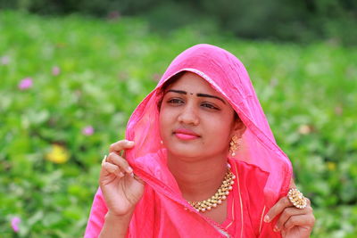 Close-up of young woman looking away while siting at farm