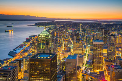 High angle view of illuminated city at sunset