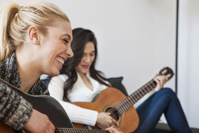 Friends practicing guitar at home