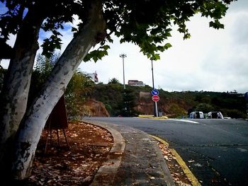 Empty road with trees in background