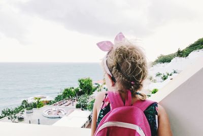 Rear view of woman looking at sea against sky
