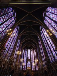 Low angle view of chapel with colorful glassa windows