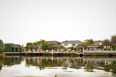 Houses by lake against sky