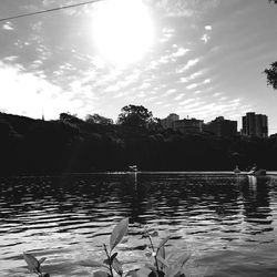 Scenic view of lake against sky in city