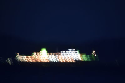 Illuminated buildings against clear sky at night