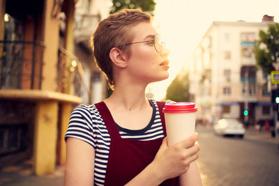 Mid adult woman looking away while standing in city