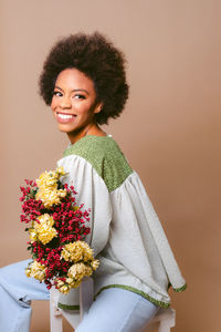 Portrait of smiling young woman holding bouquet