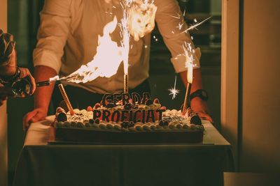 Midsection of man preparing food on barbecue grill