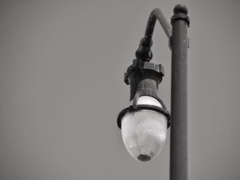 Low angle view of electric lamp against sky